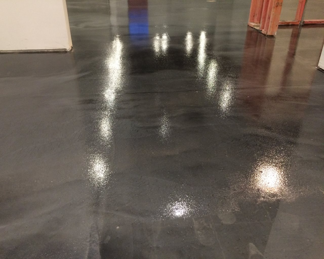 Technician applying an epoxy coating in a large commercial warehouse