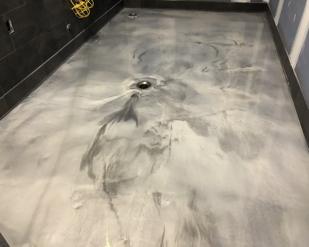 Close up of a white and gray metallic epoxy floor with natural mica flow patterns